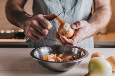 Profesyonel şef elleri büyük beyaz soğanları temizliyor.