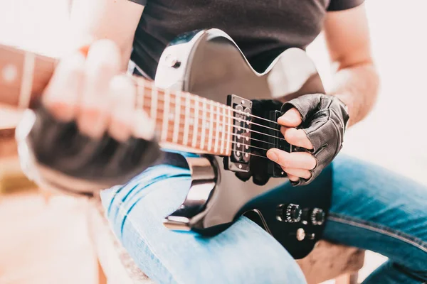 티셔츠와 청바지를 왼손잡이 일렉트릭 기타로 연주하는 — 스톡 사진
