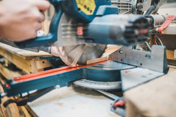 Столярный цех - мастер работает на митерной машине
