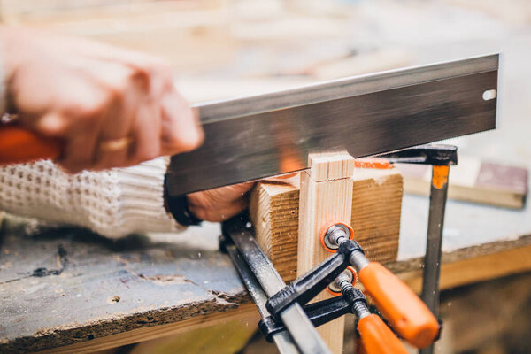Carpentry workshop - women's hands at work on wood processing
