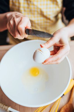 Kadın aşçı ustalıkla pişirme kabında yumurta kırar.