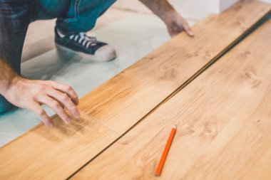 Müteahhit odaya lamine döşemekle meşgul. Tamir ve bitirme işi.