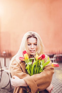 İlkbaharın başında, Mart - Bir buket lale ile genç ve çekici bir sarışının portresi