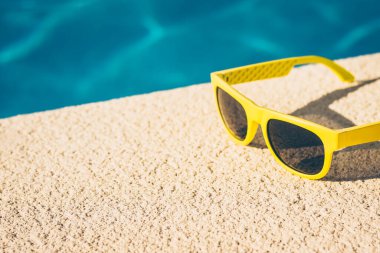 Havuz kenarında güneş gözlüğü - dinlenme tesisinde bir konsept.