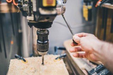 Marangozluk atölyesi - sondaj makinesi üzerinde çalışırken bir ustanın elinin yakın çekimi