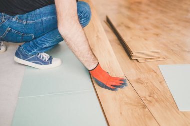 Bir işçi işini bitirirken kat kaplaması yerleştirir