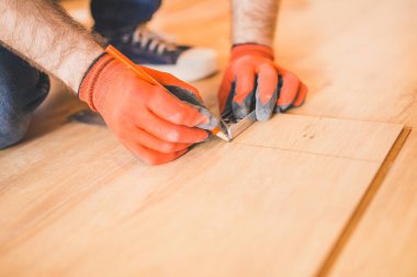 Yüzen zemin montajı - ellere yakın çekim - ev yenileme konsepti için işçi ölçümü ve işaretleme