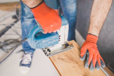 Bir işçi işini bitirirken kat kaplaması yerleştirir