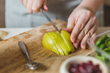 Mutfakta taze armut, zeytinyağı ve nar var. Tahta kesiminde. Sağlıklı yiyecekler.