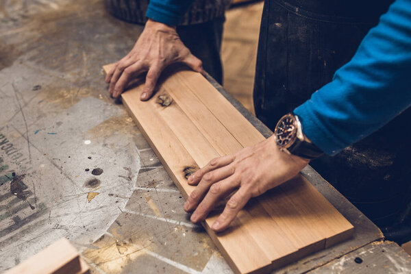 Carpentry workshop - master glues furniture panel from the bar