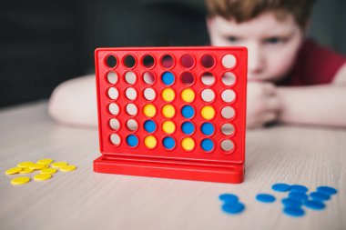 Çocuk bir masa oyununda strateji düşünüyor.