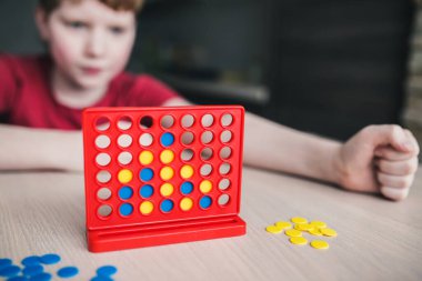 Çocuk bir masa oyununda strateji düşünüyor.