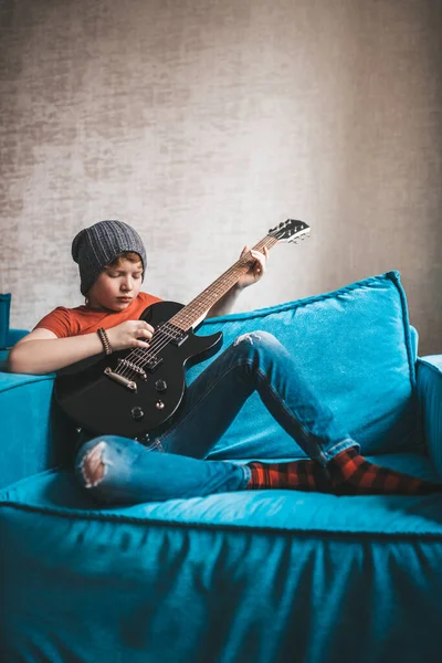 Melankolik kızıl saçlı çocuk elektro gitarda hüzünlü bir melodi çalıyor.