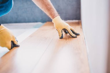 Bir işçi, profesyonel inşaat ve bitirme hizmetlerini lamine eder.