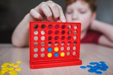 Çocuklar masa oyunu oynar - bir satırda dört bingo.