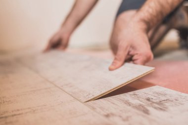 Ustanın elinin yakın çekimi döşeme döşenirken lamine kilidi bağlar