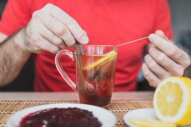 Şeffaf cam bardakta yeşil çay. Reçelli ve limonlu. Zencefil çayı.