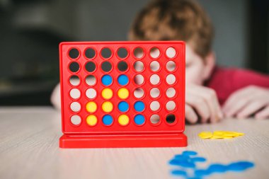 Çocuk dördüncü sırada bir masa oyunu oynuyordu. Ev eğlencesi.