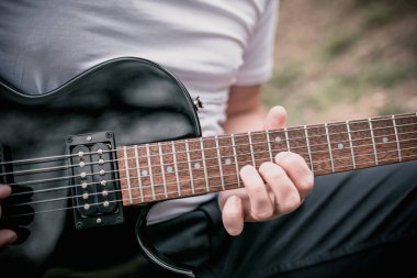 Elektro gitar çalma tekniği - açık havada çalan bir adam - heavy hard rock ve blues müziği