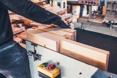 Bir kereste atölyesine yapıştırmadan önce bir çubuktaki çivileri budamak ve kesmek için kullanılan makine - kereste fabrikası - yapıştırılmış kereste üretimi