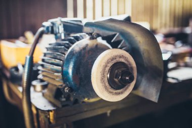 Elektrik veren makine, metal tezgahta taş öğütüyor.