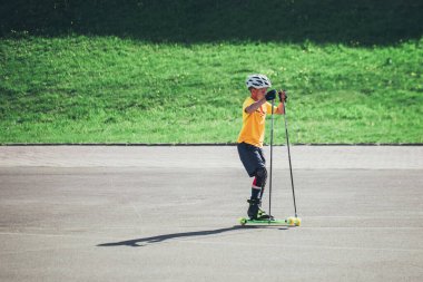 Minsk, Belarus - 22 Mayıs 2019: Çocuk çocuk aktif olarak paten pistinde ekipman sürüyor - kayak - çocuk sporu