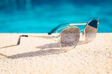 Güneşli gökyüzüne karşı güneş gözlüğü - Deniz kenarında bir yaz tatili rezervasyonu yapma zamanı