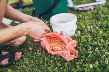 Nehir kıyısında bir balıkçı yem hazırlar.