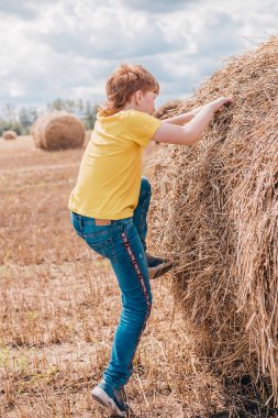 Kızıl saçlı çocuk yazın tarlada eğleniyor.