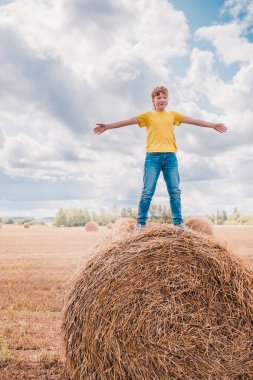 Torunum yazın köyde tatilde kolları açık bir şekilde tarlada buğday topluyor.