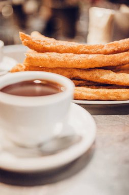 İspanyolcada churros 'u sıcak çikolatayla bir fincana daldırmak ya da çuroslu bir yemeği sütlü kahve ile servis etmek gelenektir.