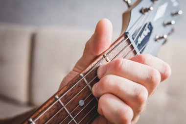 E akoru - yakın plan beyaz eli 6 telli gitarın akorunu alır