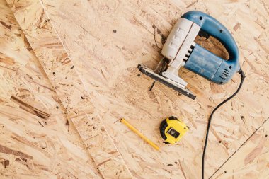 OSB 'nin bir sayfasında bir yapboz, mezura ve bir kalem bulunur.