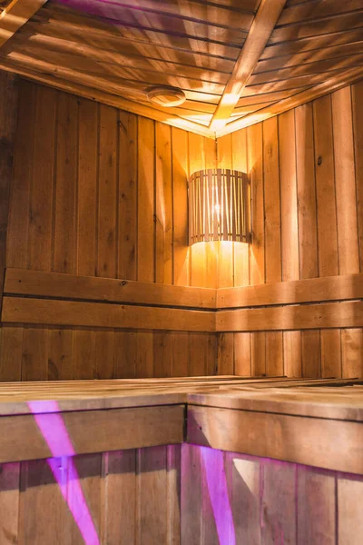 Cozy wooden steam room in the sauna with warm lighting and light wood trim