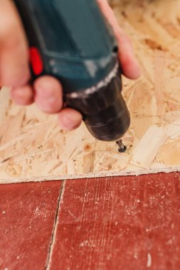 Bir devekuşu plakasını kendi kendine tıkırdatan vidalarla yükleyen bir tornavidanın yakın çekim çalışması