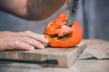 Aile Cadılar Bayramı kutlaması için hazırlanıyor. Balkabağının yüzünü kesiyorlar.