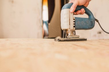 Ustanın eli güvenli ve nitelikli bir şekilde bir yapboz ile çalışıyor kontrplak tabakalarını kesiyor.