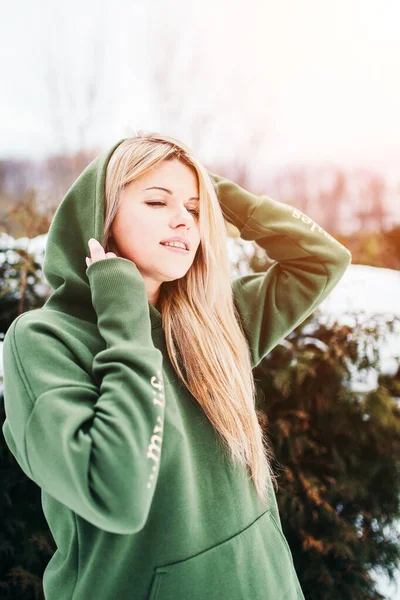 Young attractive Swedish blonde woman enjoys the warm winter sun - climate warming in the cold