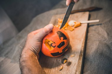 Aile Cadılar Bayramı kutlaması için hazırlanıyor. Balkabağının yüzünü kesiyorlar.