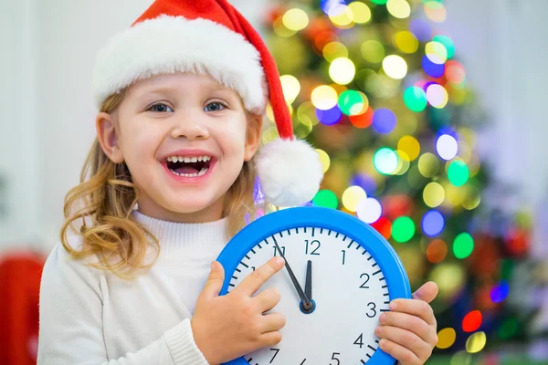 Cute girl holding clock on christmas — Stock fotografie