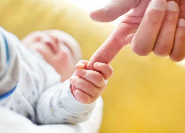 Bambino tenendo il dito papà — Foto Stock