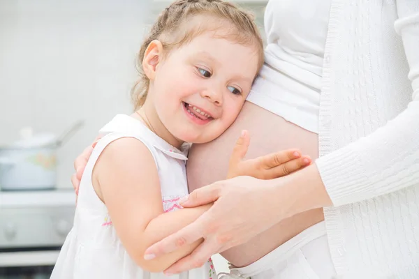 Liten flicka med mamma gravid — Stockfoto