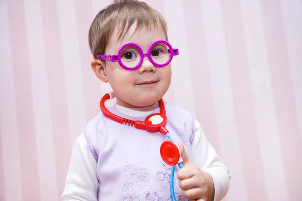 Little girl child plays at doctor — Stock Photo, Image