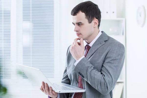 Businessman with laptop in office — Stock Photo, Image