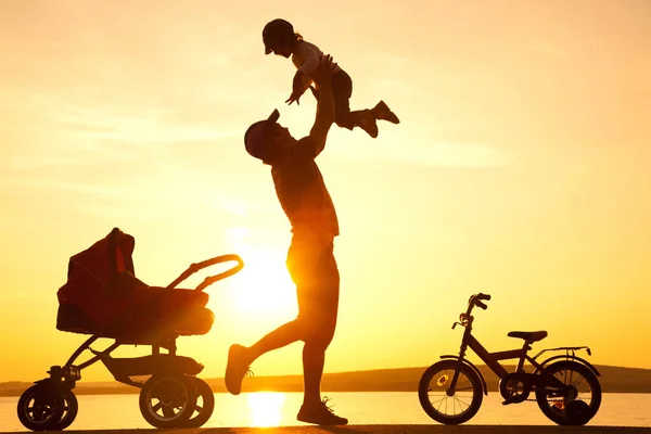 Счастливый отец с ребенком на закате — стоковое фото