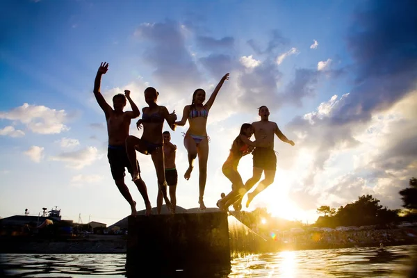 Веселые подростки на закате на пляже — стоковое фото