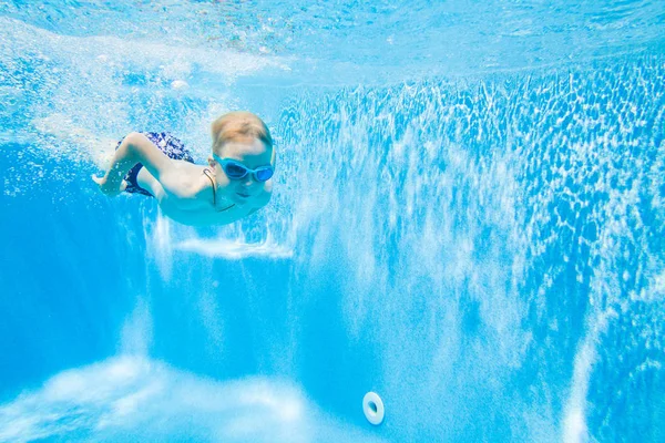 Kleine jongen zwemmen in het zwembad — Stockfoto