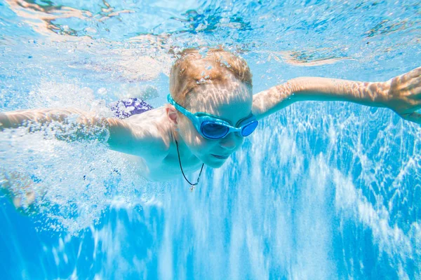 Kleiner Junge schwimmt im Pool — Stockfoto