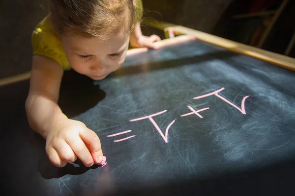 Klein meisje in de buurt van blackboard — Stockfoto