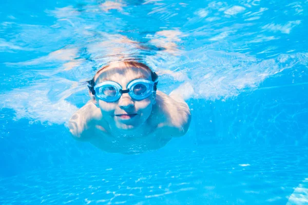 Küçük çocuk havuzda yüzüyor. — Stok fotoğraf